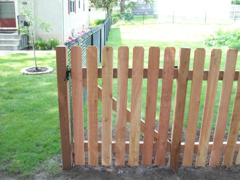 Cedar dog eared picket fence installation Minneapolis, Minnesota